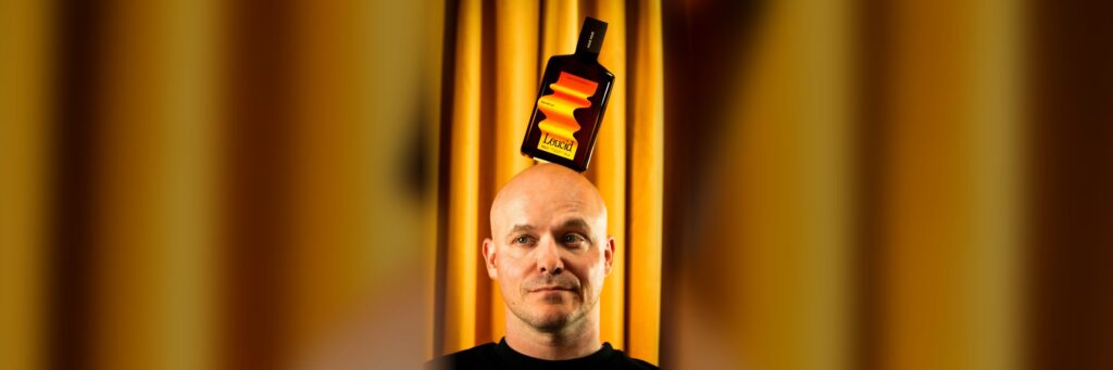 Philippe Geubels met een fles Loucid Nightcap op zijn hoofd