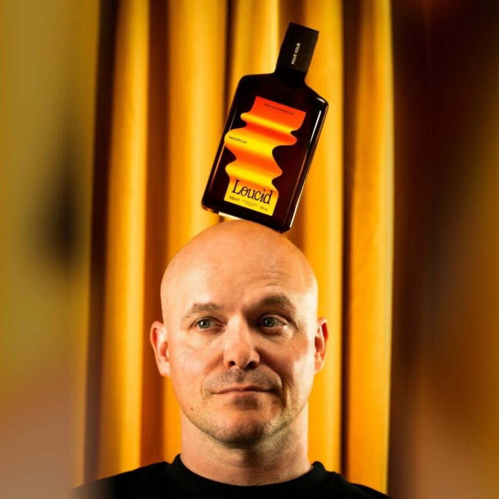Philippe Geubels met een fles Loucid Nightcap op zijn hoofd